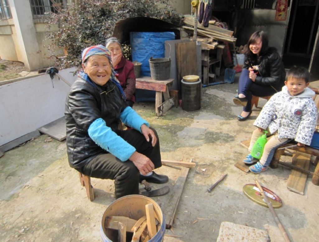 左手前のお婆さんは薪を割っている。彼らは都市部の集合住宅に<br />
居住する失地農民で、農村の生活様式をまだ維持している。<br />